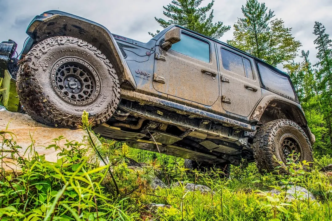 Off-road SUV climbing a ledge in the forest